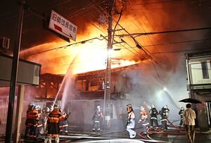 炎が上がり、消防が消火活動に当たる火災現場=10月19日午後10時30分前、上越市本町2