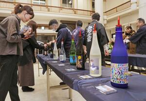 発売を前に10種類のアートラベルの日本酒がお披露目された試飲会=上越市本町3