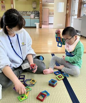 開所した施設を利用し、スタッフ(左)と遊ぶ子ども=新発田市五十公野(SMiDデイサービスにじ提供)