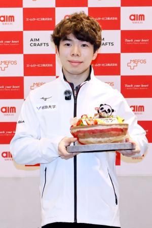 　所属先の社員交流会で贈られたケーキを手に、撮影に応じるフィギュアスケート男子の佐藤駿＝３日、東京都内