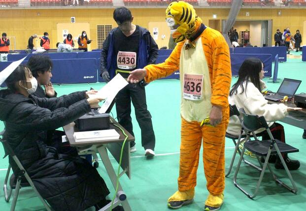 完走証を受け取る仮装ランナー＝１月１日、三条市