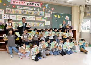 JAオリジナルの自由帳などを受け取った田上小の新1年生ら=4月16日、田上町田上乙