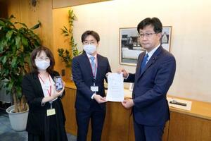 厚労省の仁木博文副大臣(右)に要望書を提出する「全国コロナ後遺症患者と家族の会」の担当者=14日午後、厚労省