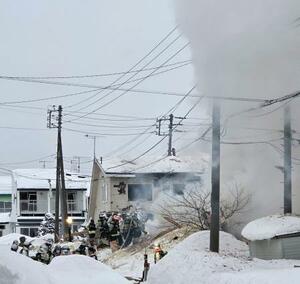 　現場付近で消火活動をする消防隊員ら＝９日午前６時５０分、札幌市手稲区