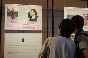 大阪・関西万博の会場に展示された、横田めぐみさんら日本人拉致被害者の写真を見る来場者=12日、大阪市此花区の夢洲