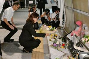 兵庫県明石市の歩道橋事故から24年、現場の慰霊碑に献花する丸谷聡子市長(左から2人目)=21日夜