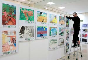 県ジュニア美術展覧会上越展の開幕を前に行われた準備作業=1月29日、上越市土橋の市民プラザ