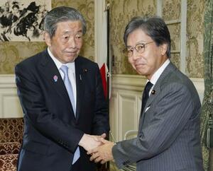 会談前に握手する自民党の森山幹事長(左)と立憲民主党の安住幹事長=16日午後、国会