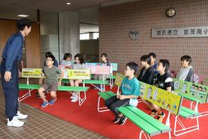 加茂南小の児童に披露された加茂五番町商店街の新しいベンチ=加茂市五番町
