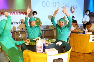 2022年の「世界えだまめ早食い選手権」団体戦で枝豆をほおばる出場者=22年7月、長岡市