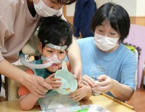 東京都内の「障害児保育園ヘレン」の研修で、子どもを見守る看護師の村井有美さん(右)=6月