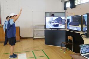 VRを使った交通安全教室で横断歩道を渡る体験をする児童=新潟市西区西有明町の青山小学校