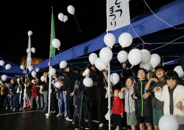 バルーンを放つ参加者＝１０月２３日、長岡市山古志竹沢