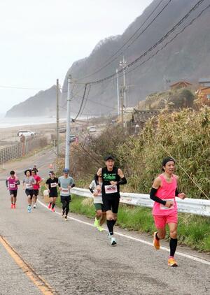 懸命に坂を駆け上がる参加者＝５日、新潟市西蒲区