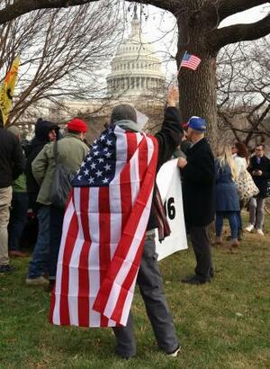　米議会議事堂前で星条旗を掲げるトランプ大統領の支持者＝６日、ワシントン（共同）