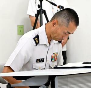 市民団体のメンバーに頭を下げ、謝罪する陸自宮古島駐屯地トップの比嘉隼人1等陸佐=19日午後、沖縄県宮古島市