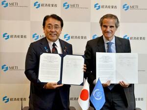 覚書を締結した赤沢経産相(左)とIAEAのグロッシ事務局長=23日午後、経産省
