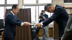 　米軍ヘリの緊急着陸を受け、防衛省沖縄防衛局の村井勝局長（右）に抗議文書を手渡す沖縄県名護市の渡具知武豊市長＝９日午前、名護市役所