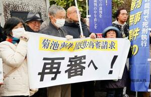 　菊池事件の再審開始を求める署名の提出前、集会を開く支援者ら＝１５日午前、熊本地裁前