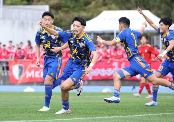 準決勝　開志学園ＪＳＣ－新潟明訓　前半６分、先制ゴールの開志学園ＪＳＣのＤＦ金子勇人（６）が駆け出す＝新発田市五十公野公園陸上競技場