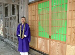 本堂のハートマークの扉と山田光哲住職=燕市国上