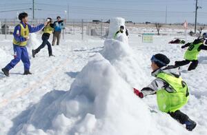 相手陣地の的に向かって思い切り雪玉を投げる参加者＝上越市