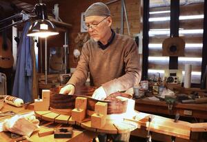 「tamaniwaワークショップ」の工房でギターを作る浜崎浩さん=山形県川西町