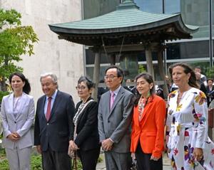 　「平和の鐘」の前で記念撮影する、（左２人目から右に）国連のグテレス事務総長、高瀬聖子さん、山崎和之国連大使ら＝１２日、米ニューヨークの国連本部（共同）
