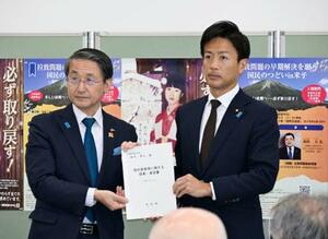 　鳥取県の平井伸治知事（左）から拉致問題の完全解決を求める要望書を受け取る鈴木隼人内閣府副大臣＝２４日午後、鳥取県米子市