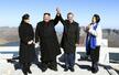 　朝鮮半島最高峰の白頭山でつないだ手を上げる北朝鮮の金正恩朝鮮労働党委員長（中央左）と韓国の文在寅大統領（同右）。夫人が同行した＝２０１８年９月２０日（平壌写真共同取材団・共同）