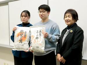 JA佐渡女性部の頓宮愛子さん(右)から新米を受け取った佐渡看護専門学校の生徒=佐渡市千種