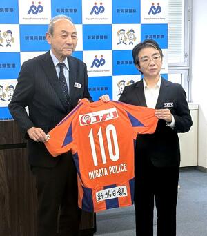 背番号「110」の特別ユニホームを贈るアルビレックス新潟の中野幸夫社長(左)=4月4日、県警本部