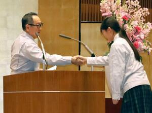 トヨタ工業学園の卒業式で、卒業生の山口なみさん(右)を激励するトヨタ自動車の豊田章男会長=27日午前、愛知県豊田市