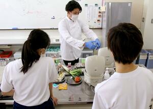 吉川高等特別支援学校の生徒に料理を教える信田紘基さん=7月16日、上越市吉川区原之町