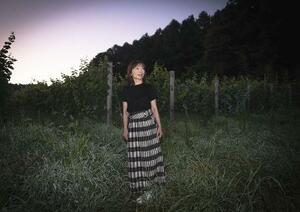 夜明け前、自らも作業を手伝うブドウ畑にやってきた小野梨奈。「日本での有機還元葬を実現させたい」と目を輝かせる=2025年7月、長野県東御市(撮影・今里彰利)