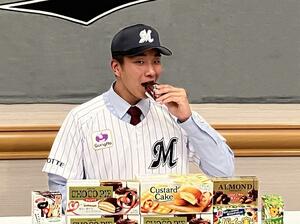 好物のロッテのチョコパイを口にする帝京長岡高の茨木佑太(球団提供)