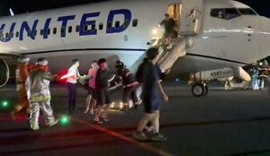 関西空港に緊急着陸した米ユナイテッド航空機から、脱出用シューターを使って避難する乗客=12日(乗客提供)