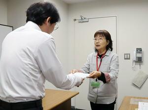新潟労働局の担当者に要請書を手渡す県労連の寺崎洋子議長(右)=30日、新潟市中央区