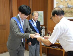加藤博幸市長(右)に、防犯機能付き電話機の目録を手渡す永松健太郎会長=阿賀野市役所