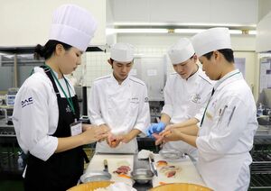 すしの握り方を学ぶウソン情報大の学生(両端)=8月28日、新潟市中央区東幸町