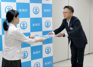 交通安全マップを寄贈するあいおいニッセイ同和損害保険執行役員の河上直人さん(右)=新潟市役所