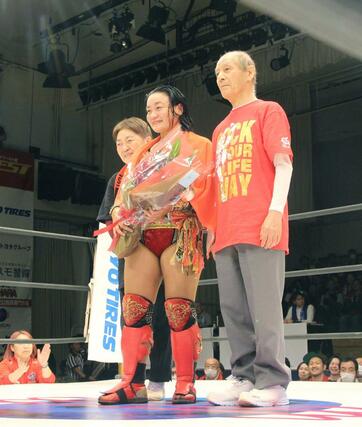 両親からリングで花束を受け取る里村明衣子選手（中央）＝４月２９日、東京・後楽園