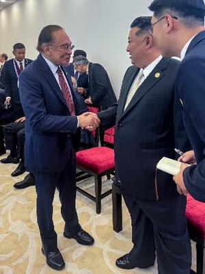 マレーシアのアンワル首相(左)と握手を交わす北朝鮮の金正恩朝鮮労働党総書記=3日、北京(アンワル氏のフェイスブックから、共同)