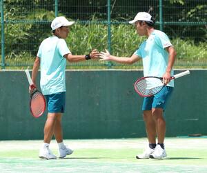東京学館-開志国際 テニス男子団体決勝でプレーする伊藤唯(左)と主将の大内大雅=南魚沼市の大原運動公園