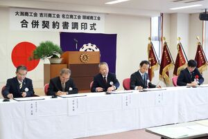 「くびきの商工会」発足に向けた合併契約書の調印式=12月10日、上越市大潟区