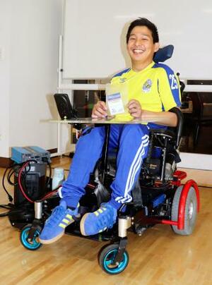 　電動車いすに乗り、笑顔を見せる三上勇輝さん＝９月、神奈川県藤沢市