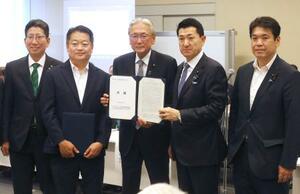 　火山防災に関する決議を受け取る赤間防災相（右から２人目）＝１８日午後、国会