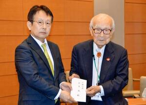 外務省の中村仁威軍縮不拡散・科学部長(左)に要請書を手渡す被団協の田中熙巳代表委員=20日午後、東京都千代田区