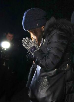 　１９４キロ死亡事故現場で手を合わせる遺族＝９日夜、大分市