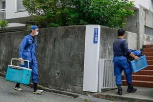 大型冷凍庫から成人男性の遺体が見つかったマンションに出入りする捜査員=22日午前、神戸市中央区